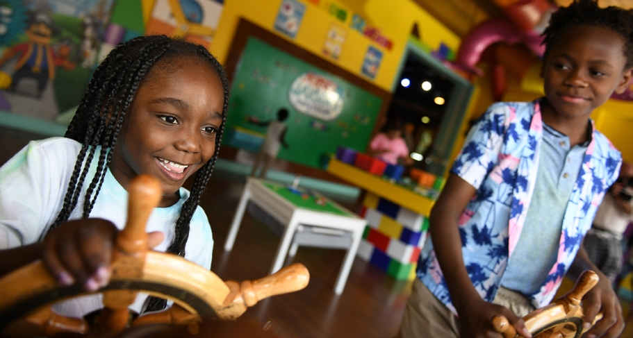Girl holding a toy boat steering wheel