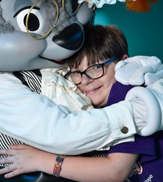 A young boy hugging a person in a rabbit suit