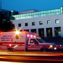 Leon County ambulance driving by a building