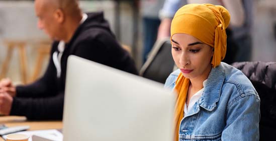 Femme travaillant dans un studio de design regardant son écran d’ordinateur