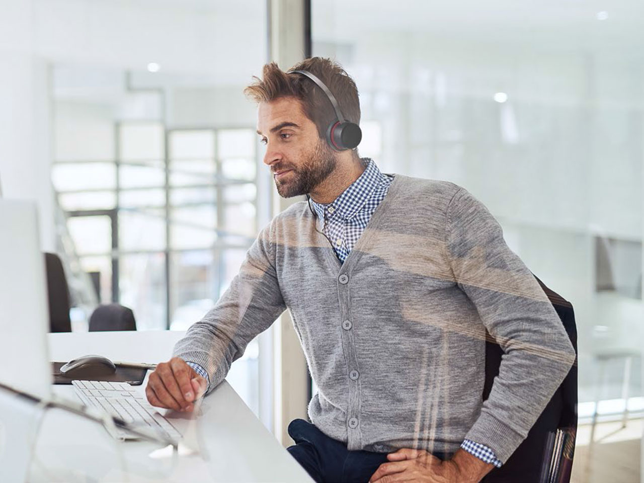 Man sat at desk with PC and headet