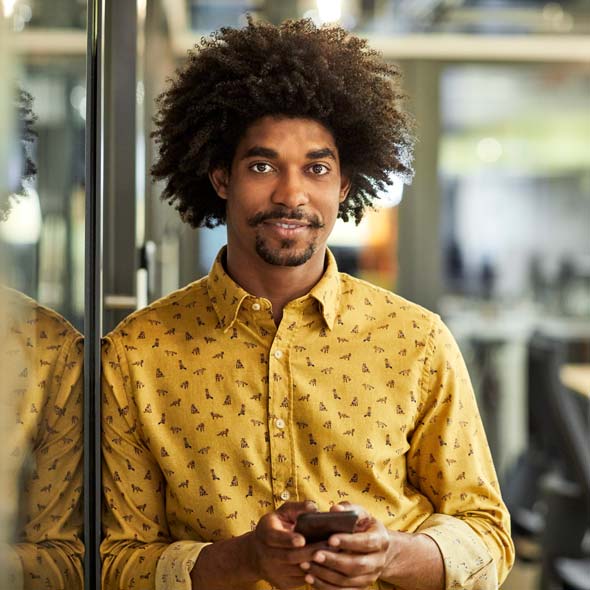 African American businessman with mobile phone in office