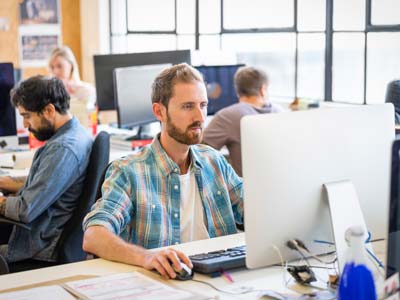 Professionals using computers at desk in office