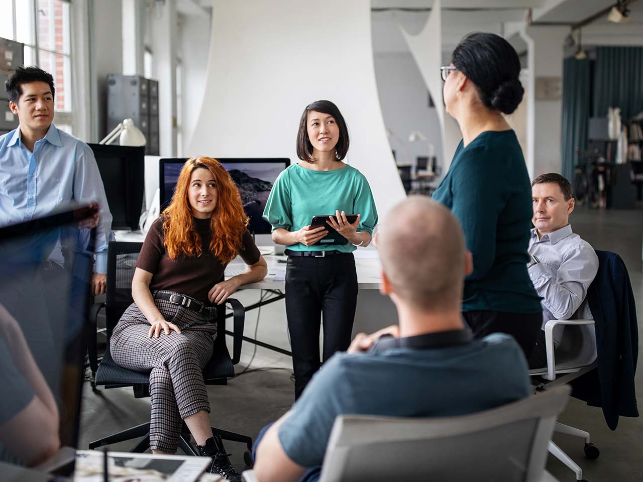 Team of people in an office having a discussion.