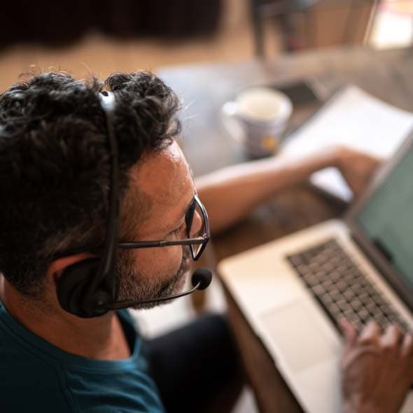 Man working from home, using headset during video call or customer call 