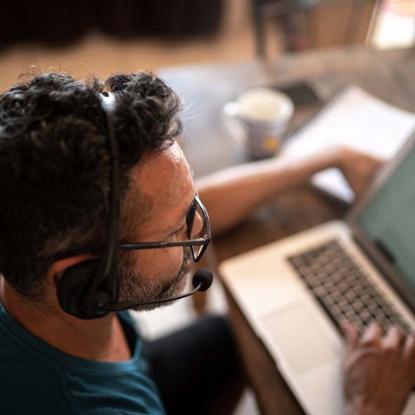 Man working from home, using headset during video call or customer call 