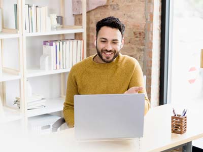 Man uses laptop to video conference with friends