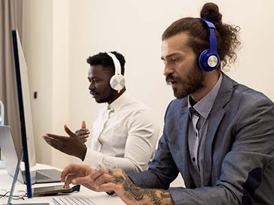 Two male call center agents responding to calls