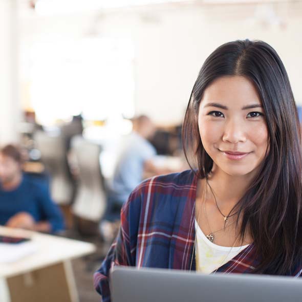 Businesswoman using laptop in modern office.
