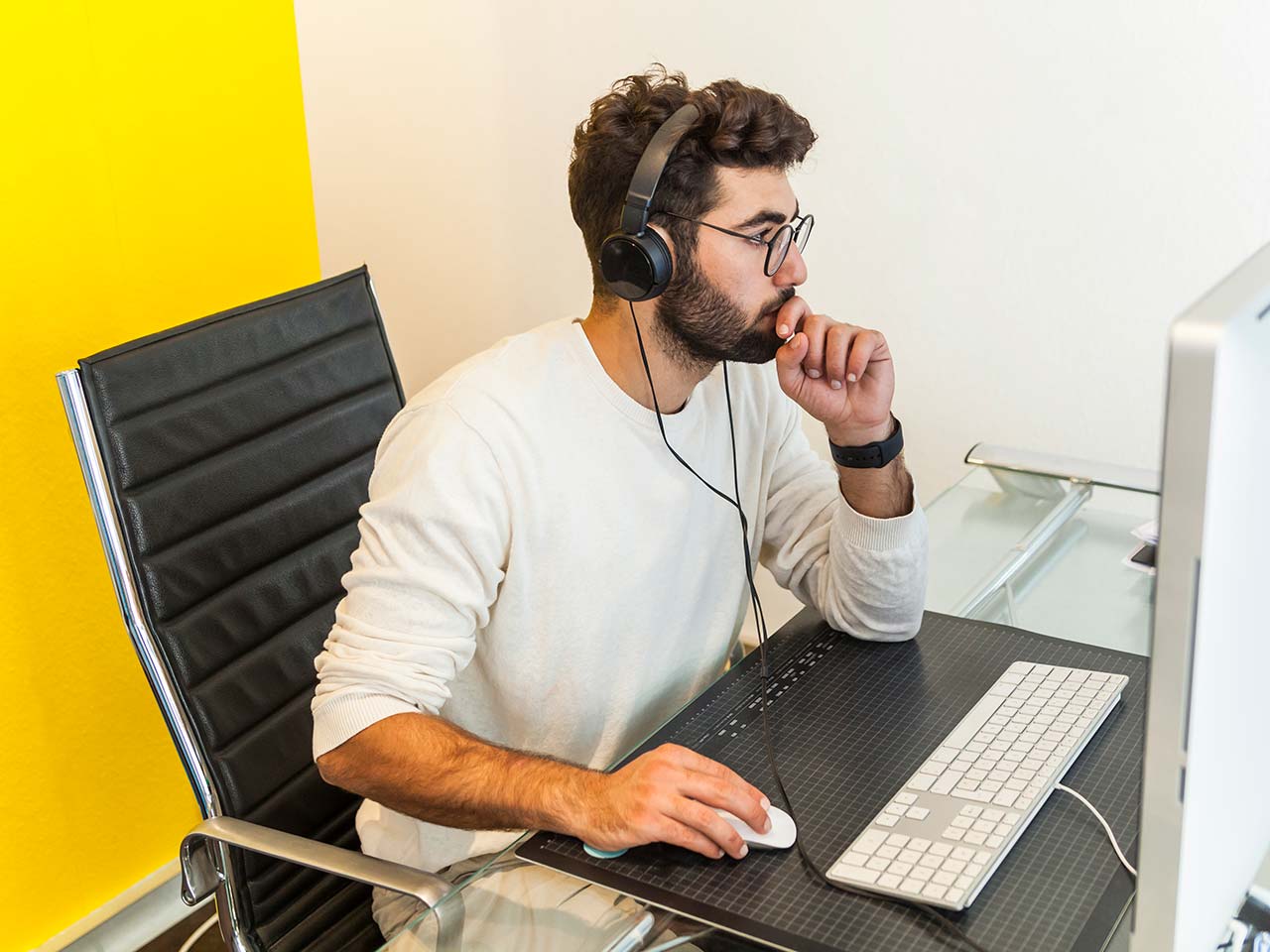 Man working at desk wearing headset.