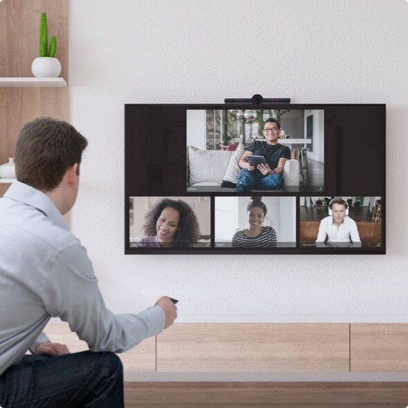 Man in front of a tv screen talking to others on ACO Rooms