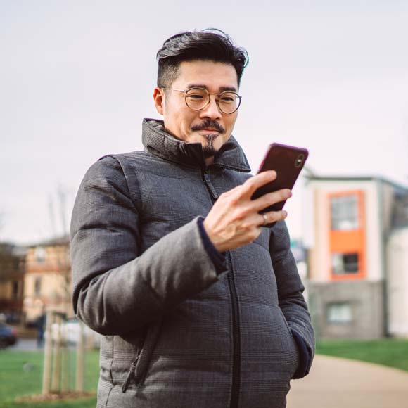 Man Smiling While Using Smartphone