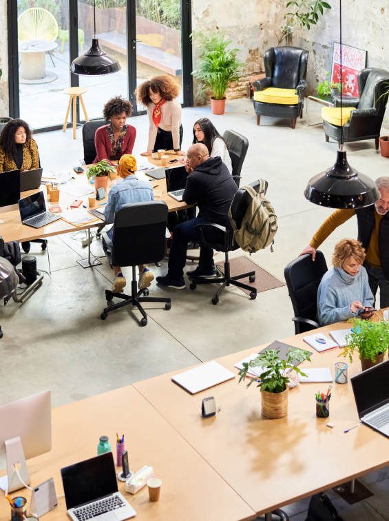 Open office viewed from the top, workers at desks talking