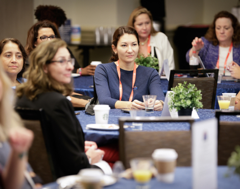 Women sat in a conference audience.