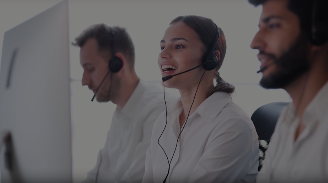 Three call center agents with headsets talking.
